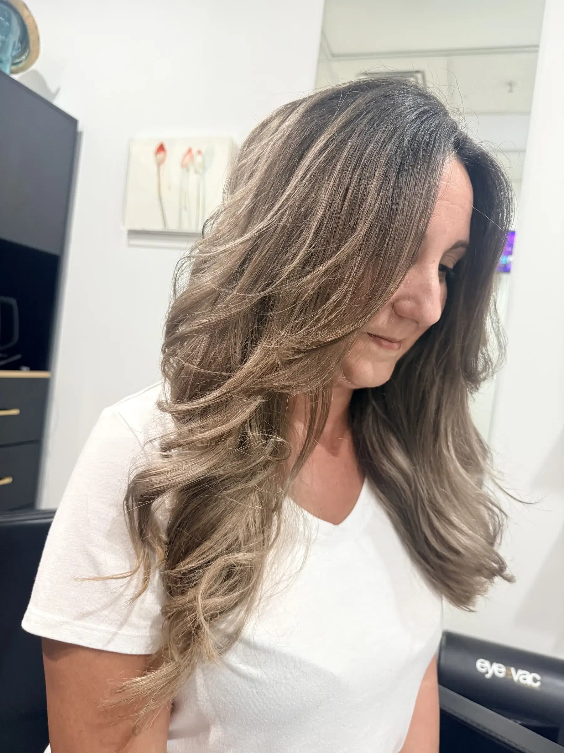 Soft, rooted ash bronde in long face-framing waves after a color correction
