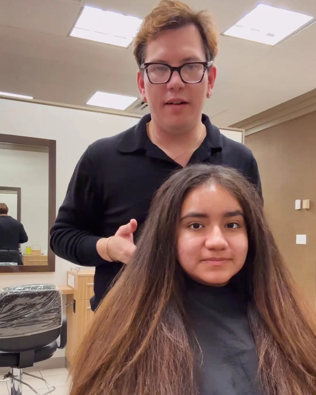Rudy Perez studying a clients hair during a consultation